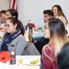 Students smiling at guest speaker during lunch